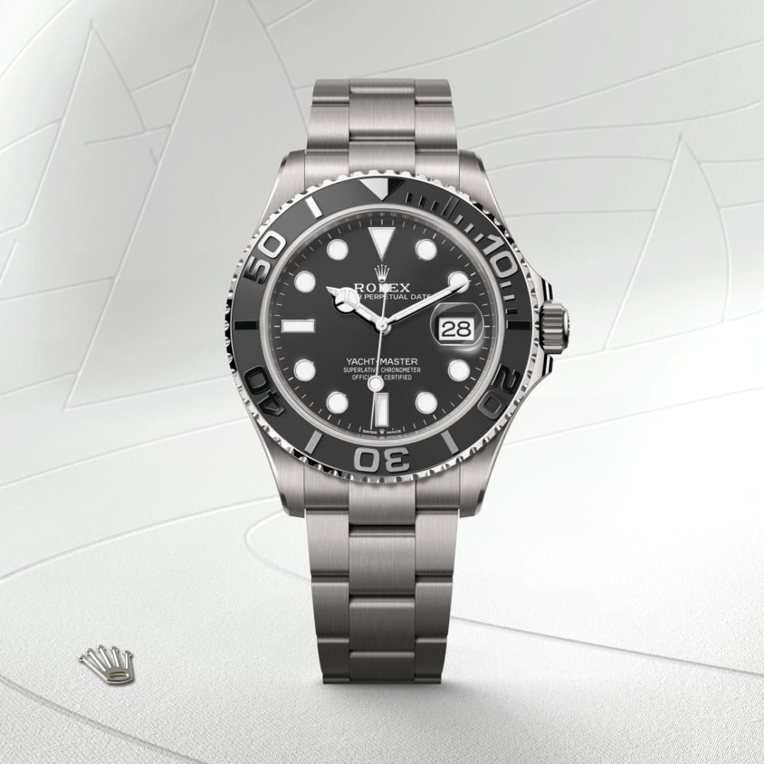 Stainless steel Rolex Yacht-Master watch with black bezel and dial, displayed on a light textured background.