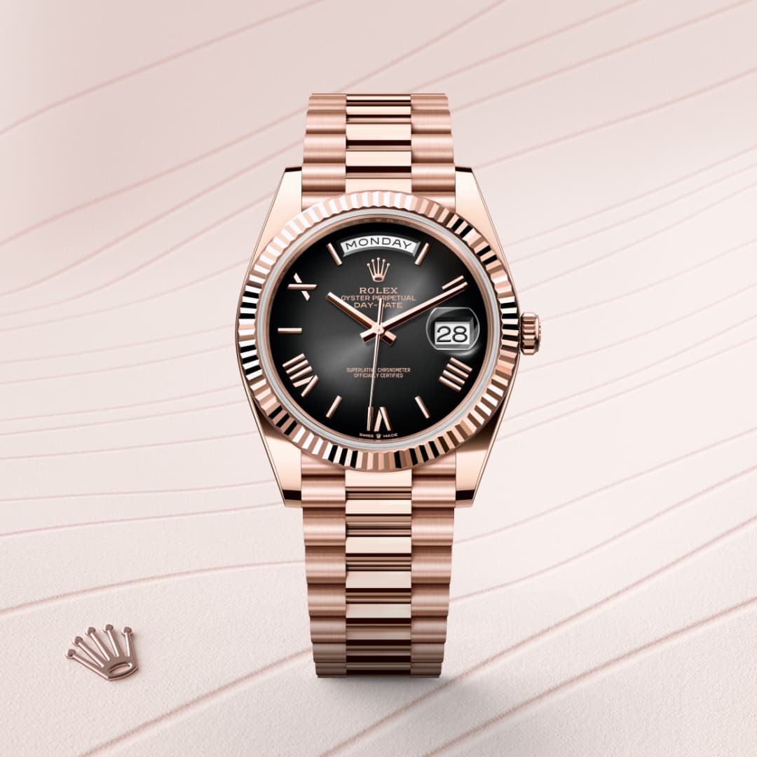 A rose gold Rolex watch with a black dial and date display on a striped light background.