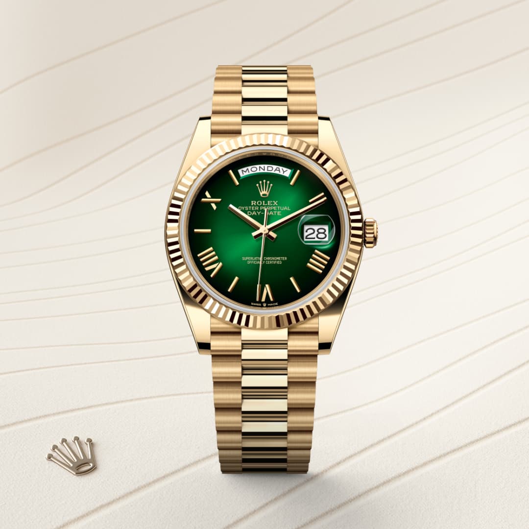 A gold Rolex watch with a green dial and date display, shown on a textured cream background.