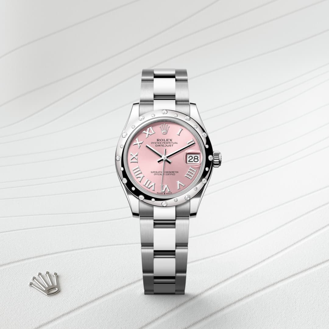 A silver Rolex watch with a pink dial and Roman numerals, displayed on a textured white surface.