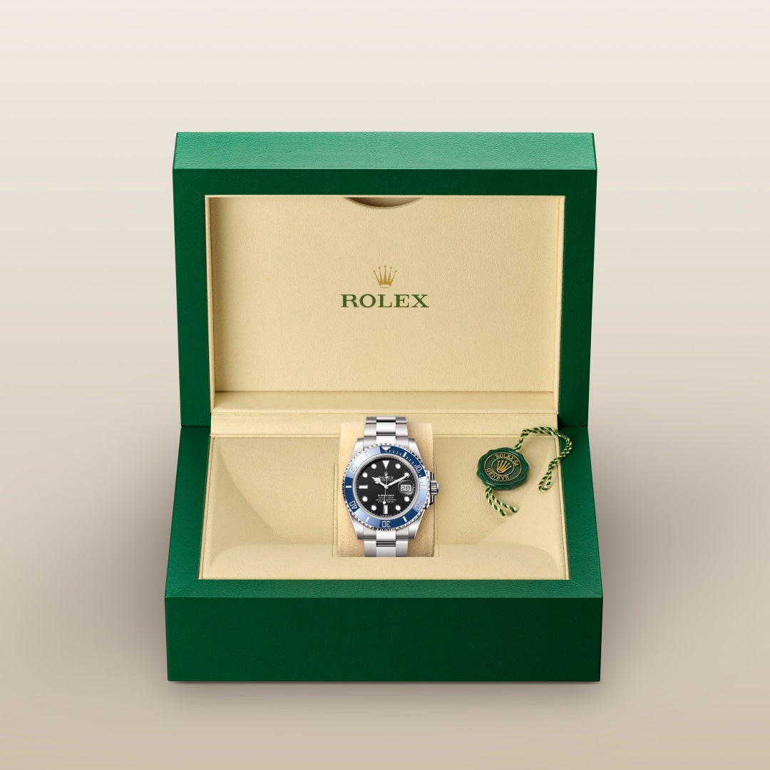 Rolex watch with a black dial in a green and beige box, featuring the Rolex logo and a green tag.