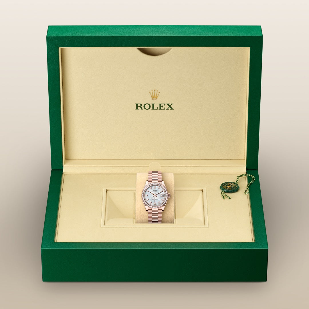 A Rolex watch with a two-tone band displayed in an open green and beige Rolex box.
