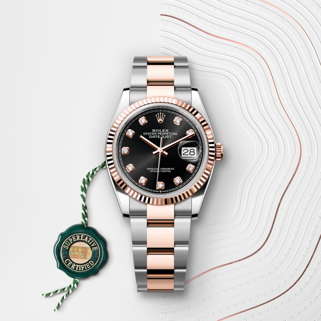 A Rolex Datejust watch with a black dial, diamond markers, two-tone band, and a green Superlative Certified tag.