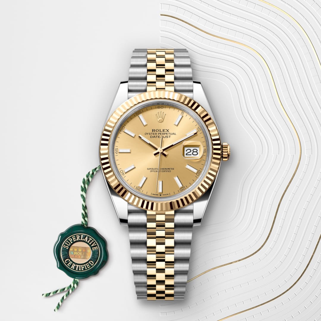 A gold and silver Rolex Datejust watch with a fluted bezel, shown with a green Superlative Certified tag.