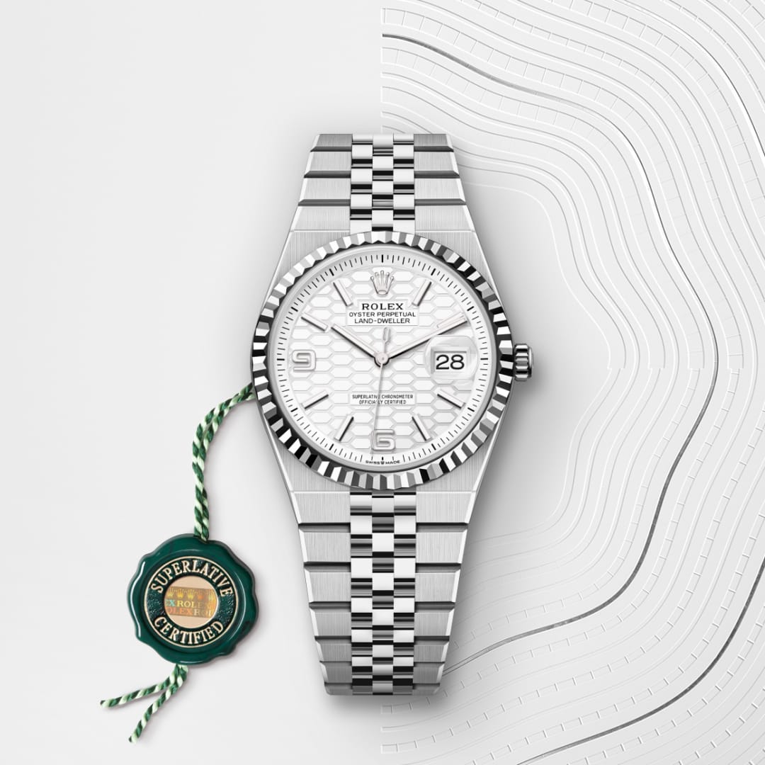 A silver Rolex watch with a white textured face and date display, shown with a green Superlative Certified tag.