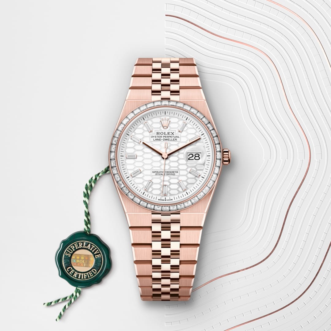 A rose gold Rolex watch with a white face and date display, next to a green Superlative Certified tag.