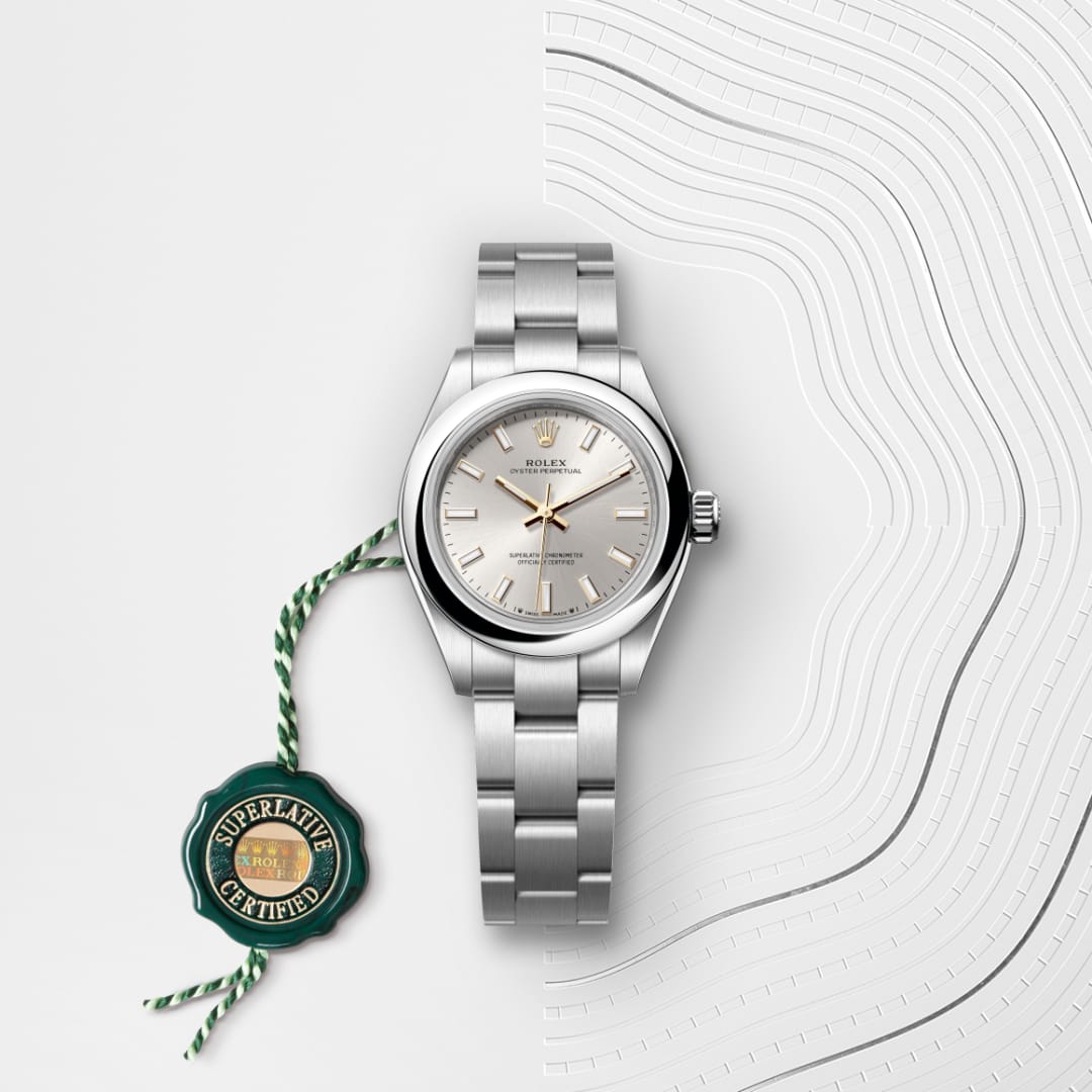 A silver Rolex watch with a metal band, next to a green Superlative Certified tag on a textured background.