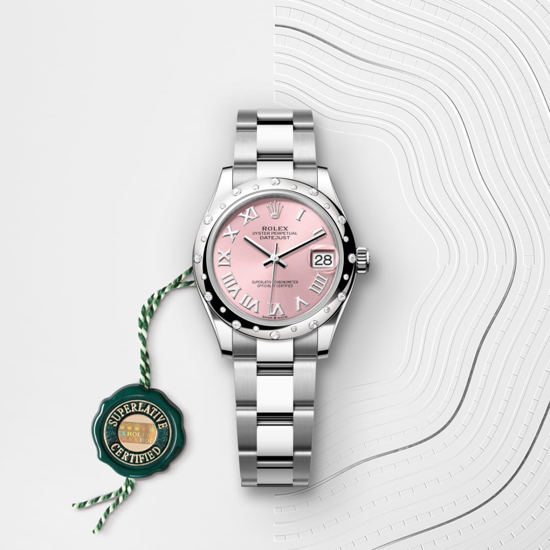 A Rolex watch with a pink dial and silver band displayed next to a green Superlative Certified tag.