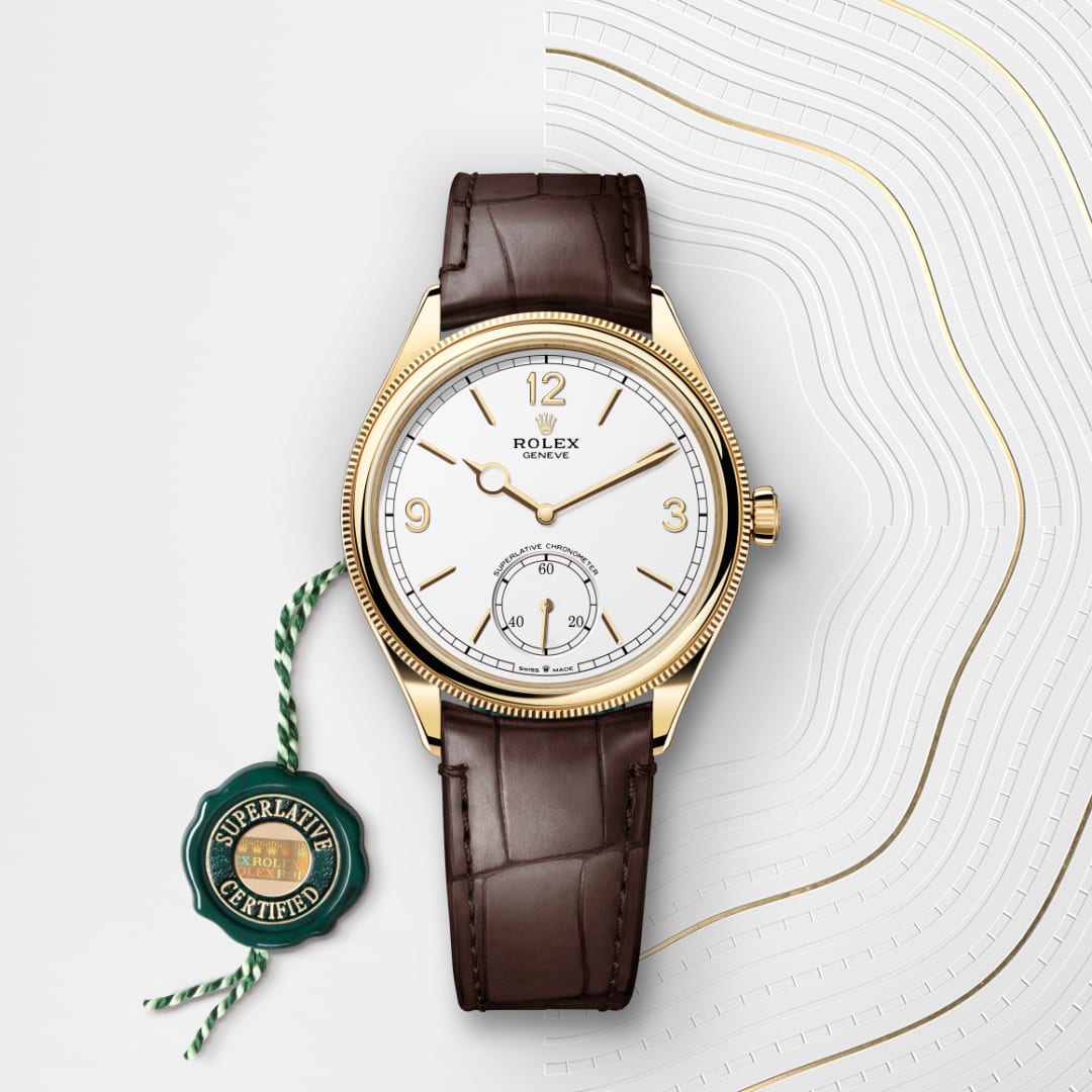 A gold Rolex watch with a brown leather strap and Superlative Certified tag on a white patterned background.