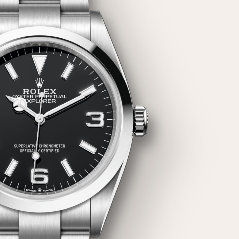Close-up of a Rolex Oyster Perpetual Explorer watch with a black dial and silver metal band.