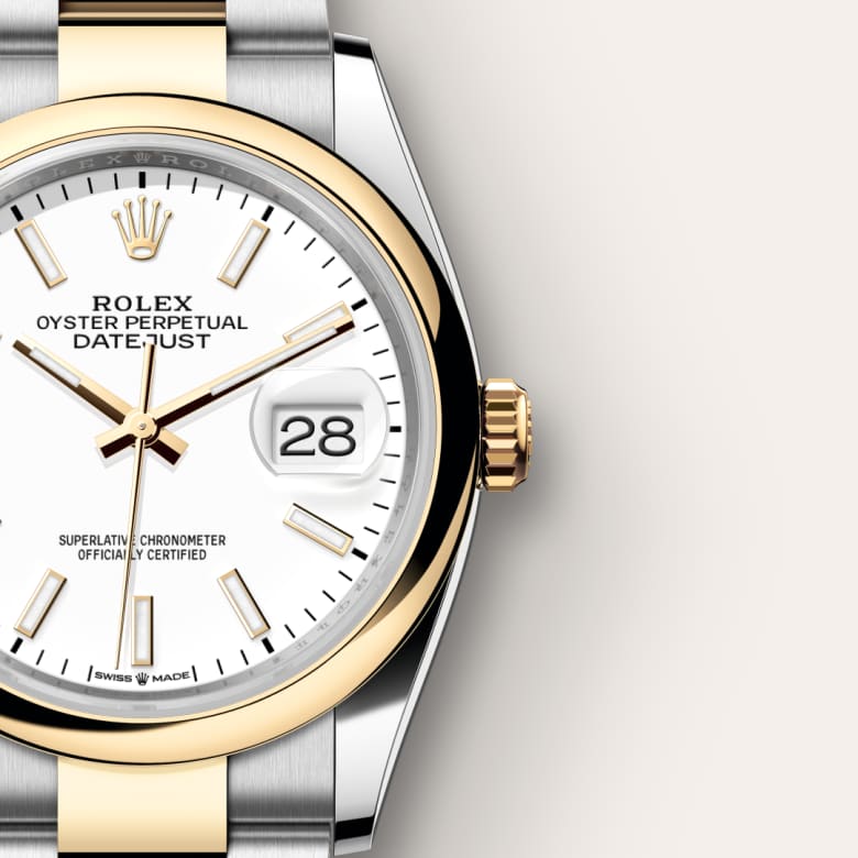 Close-up of a Rolex Oyster Perpetual Datejust watch with a white dial, gold bezel, and date display.