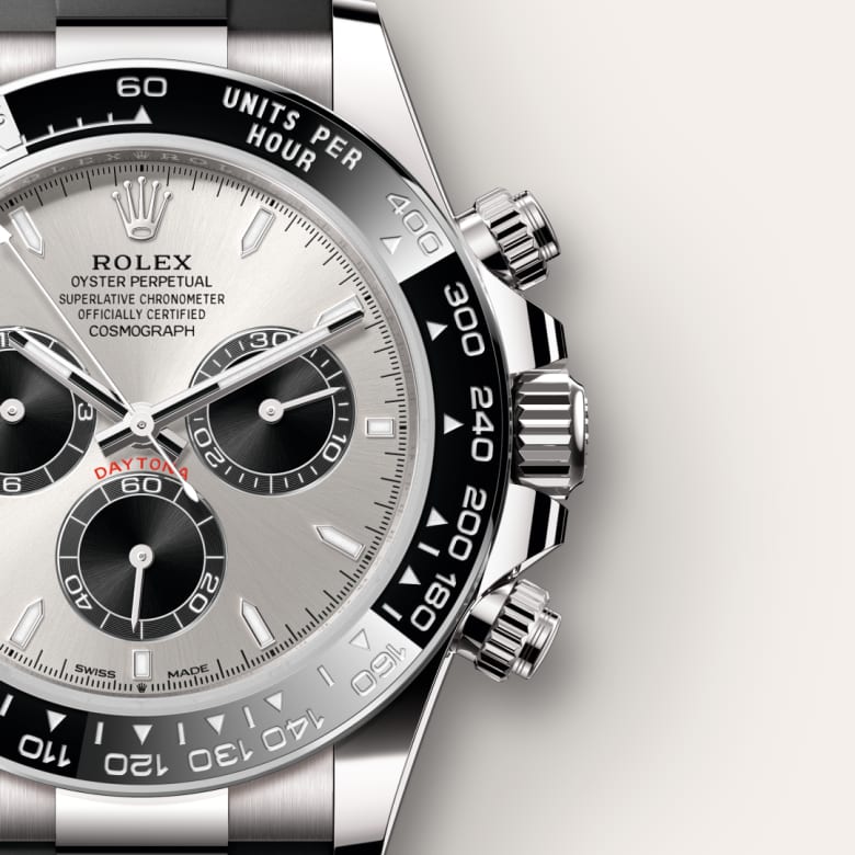 Close-up of a silver Rolex Daytona watch with black subdials and a tachymeter bezel.