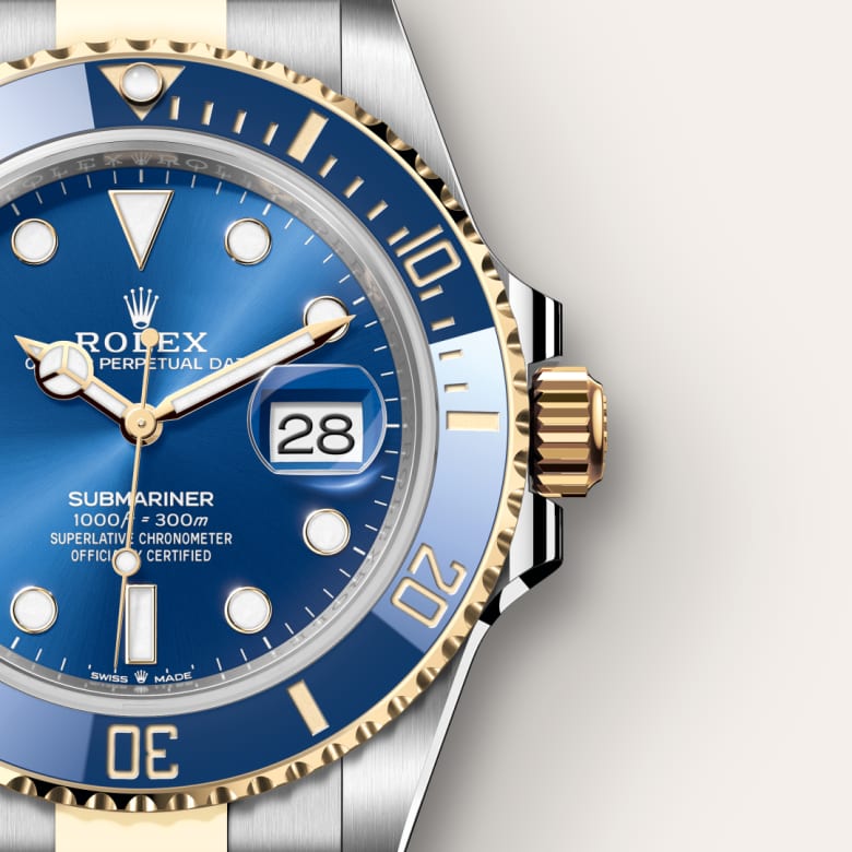 Close-up of a Rolex Submariner watch with a blue dial, gold accents, and date display set to the 28th.