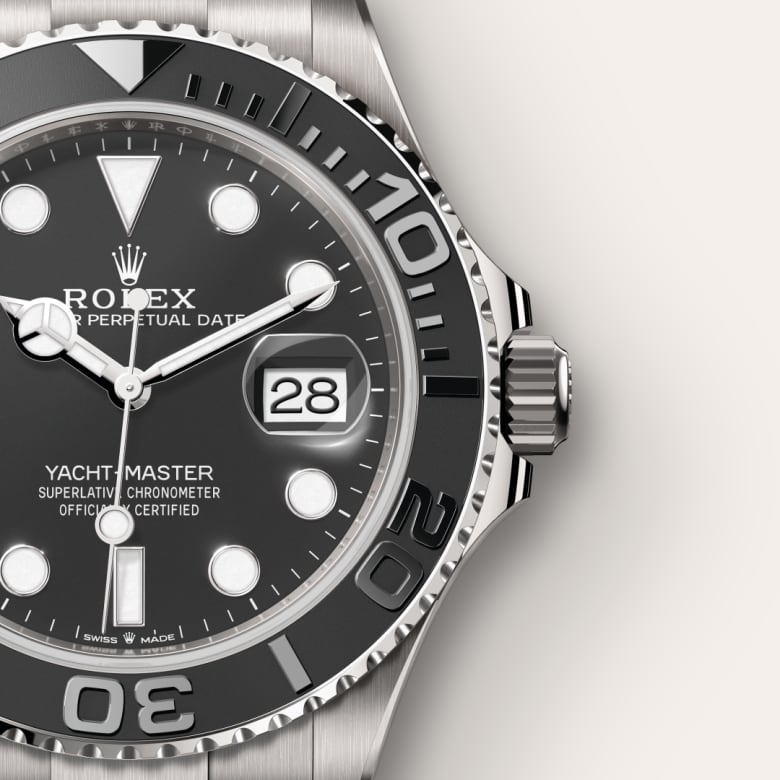 Close-up of a Rolex Yacht-Master watch with a black bezel and silver casing, showing the date as 28.