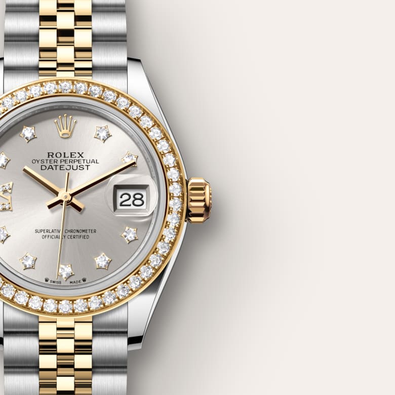 Close-up of a Rolex Datejust watch with diamond markers, gold bezel, and a two-tone metal bracelet.