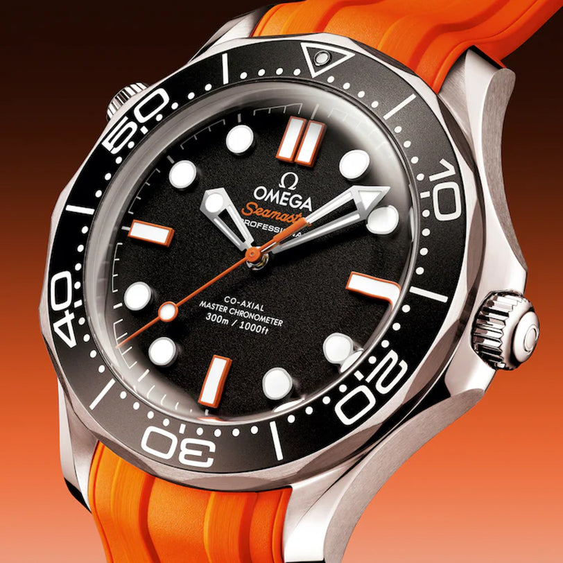 A close-up of the OMEGA Seamaster Diver 300 watch, featuring an orange strap and black dial, set against a gradient background.