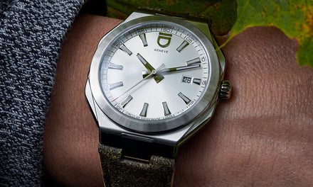 Close-up of a silver wristwatch with a leather strap on a persons wrist, showing the time as 1:51.
