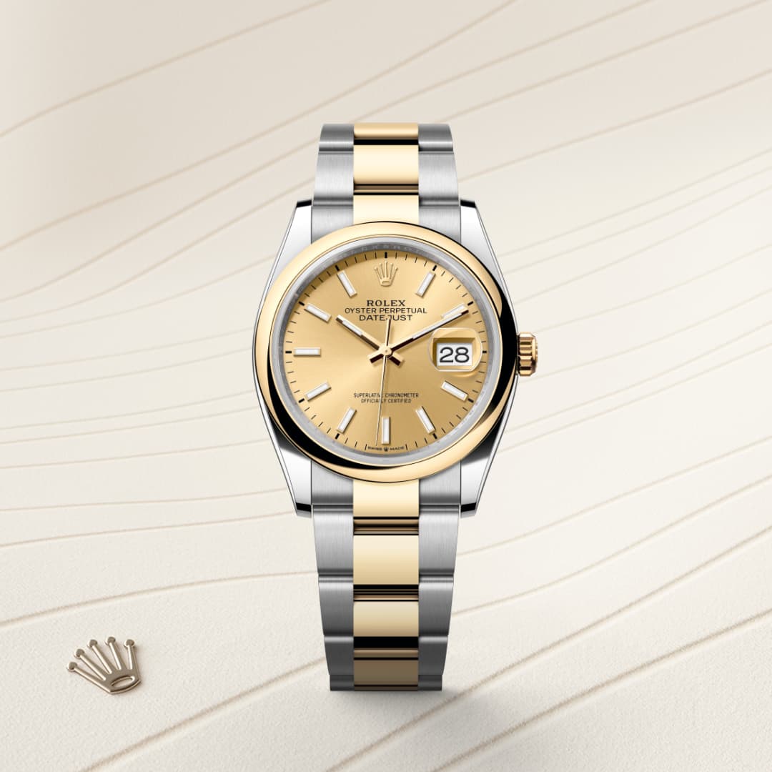 Two-tone Rolex watch with a gold dial and date window on a patterned beige background.