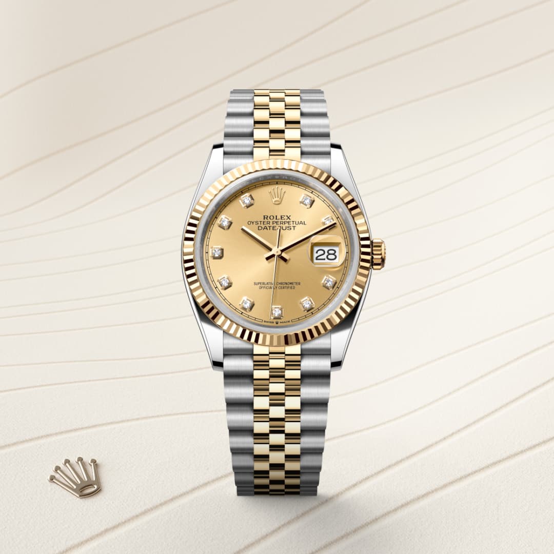 A two-tone Rolex watch with a gold dial and diamond hour markers on a light textured background.