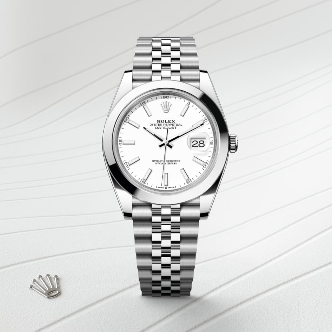 Silver Rolex watch with a white dial and date display, on a silver metal band, placed on a textured white surface.