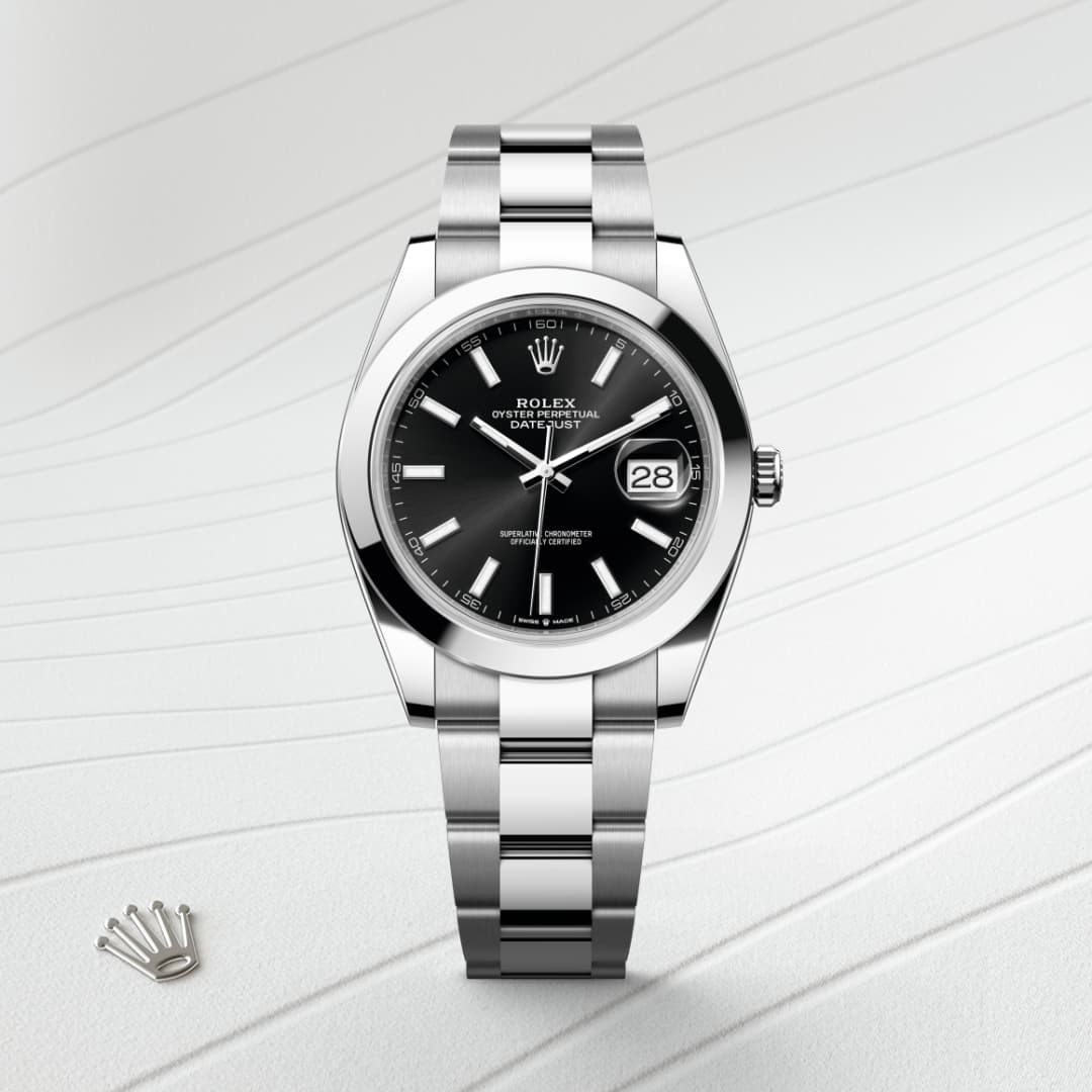 Silver Rolex watch with a black dial and date display, placed on a textured white surface.