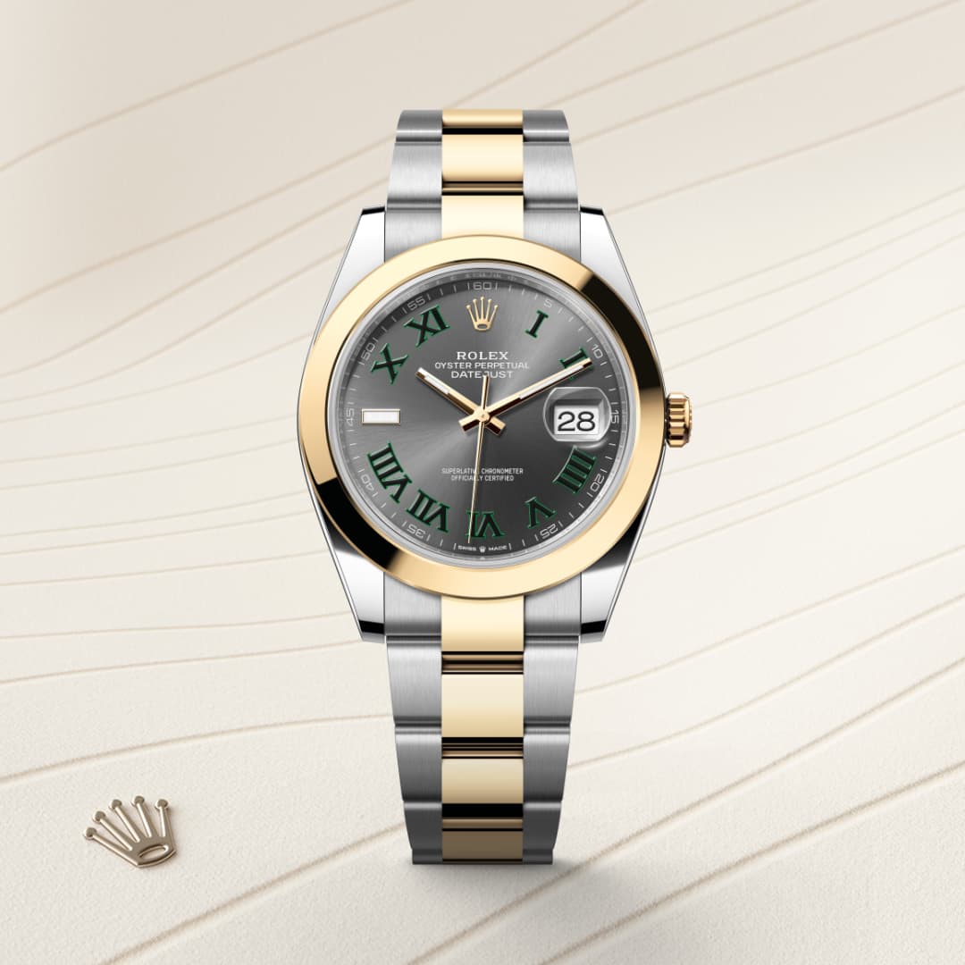 A Rolex Datejust watch with a silver and gold band, gray dial, green Roman numerals, and a date window.