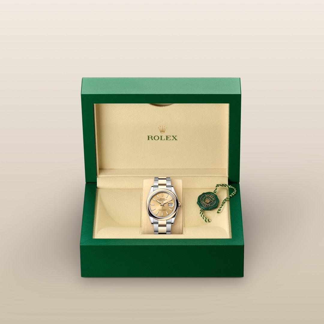 A Rolex watch in a green box with a gold interior, alongside a green tag.