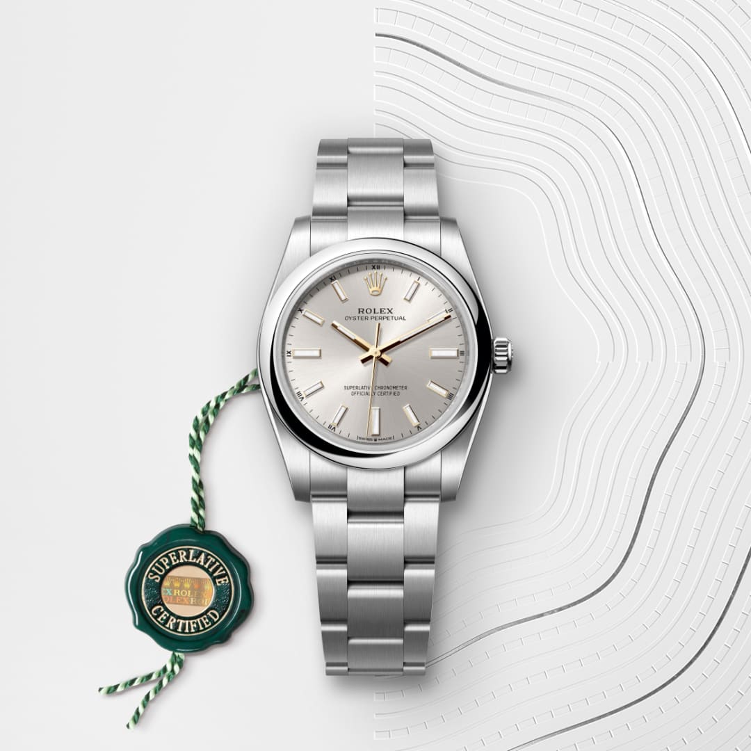 A silver Rolex Oyster Perpetual watch with a green Superlative Certified tag on a textured white surface.