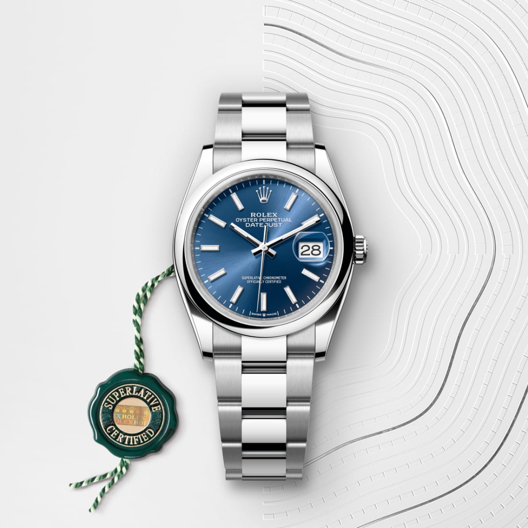 Silver Rolex watch with a blue dial and date display, shown with a green Superlative Certified tag.