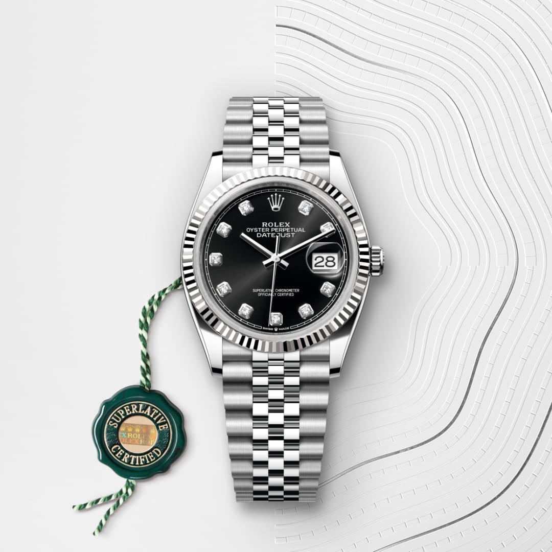 Rolex Datejust watch with a black dial and diamond markers on a silver bracelet, shown with a green certification tag.