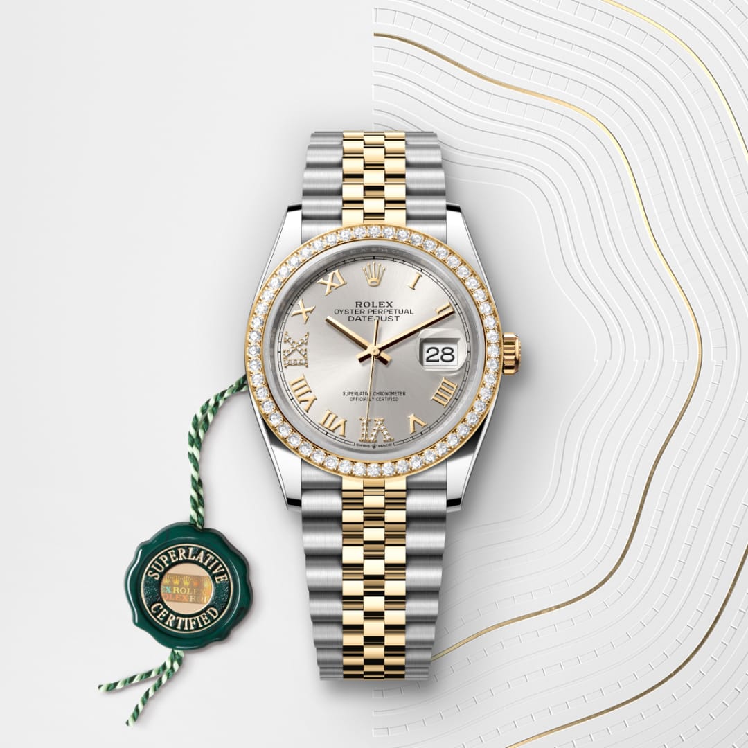 A two-tone Rolex watch with a diamond bezel, Roman numerals, and date display, shown with a certification tag.
