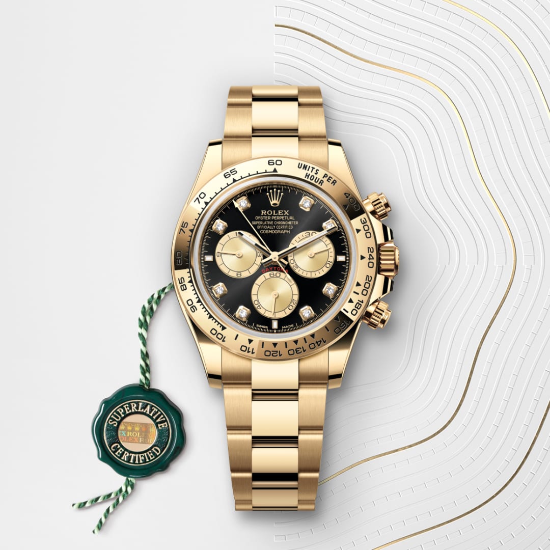 Gold Rolex Daytona watch with black and gold dial, three subdials, and a green Superlative Certified tag.