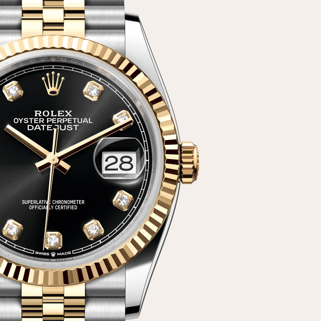 Close-up of a Rolex Datejust watch with a black dial, gold and silver band, and diamond hour markers.