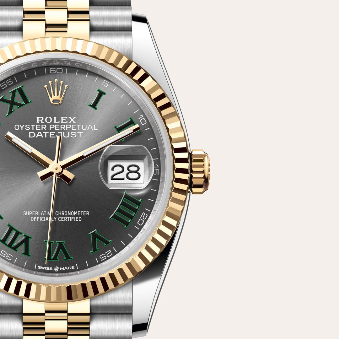 Rolex Datejust watch with green Roman numerals, gold bezel, and two-tone bracelet, showing date as 28.