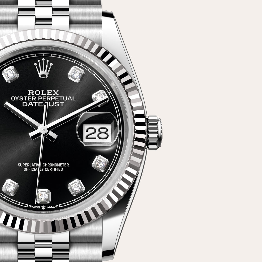 Close-up of a Rolex Datejust watch with a black dial, diamond hour markers, and the date displayed at 3 o’clock.