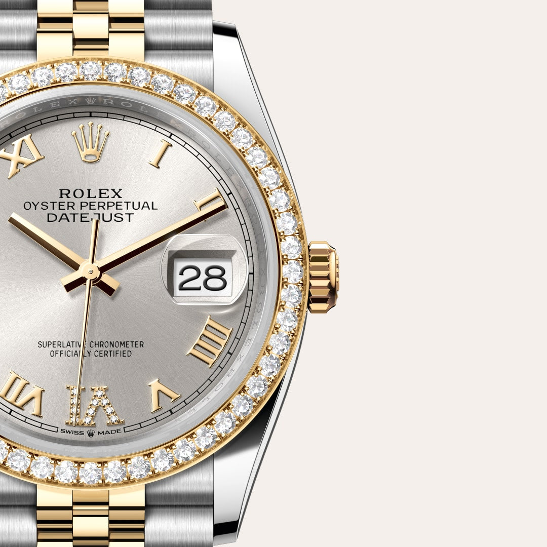Close-up of a Rolex Datejust watch with a diamond bezel, Roman numerals, and a silver dial showing the date 28.