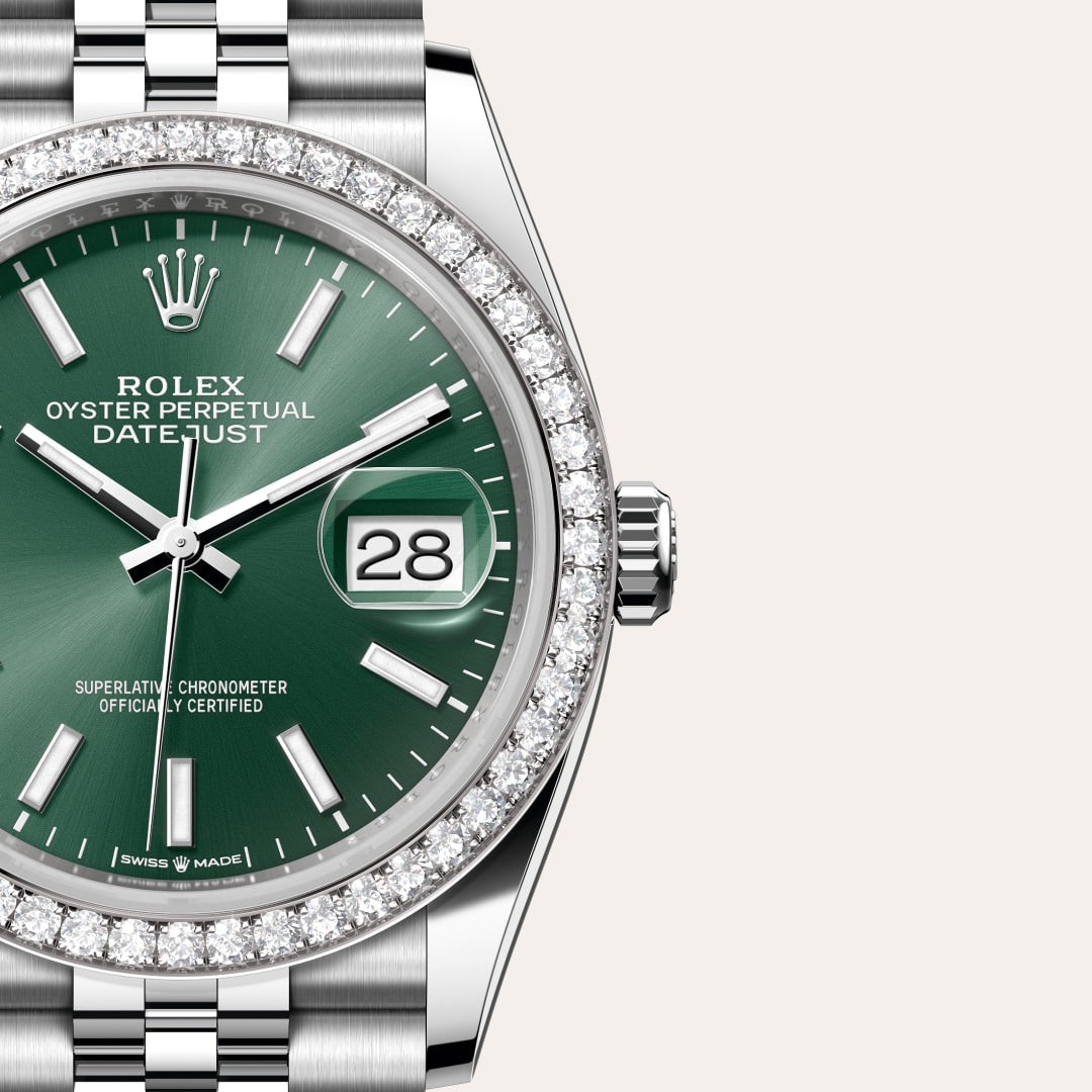 Close-up of a green Rolex Datejust watch with a diamond bezel and silver bracelet, displaying the date.