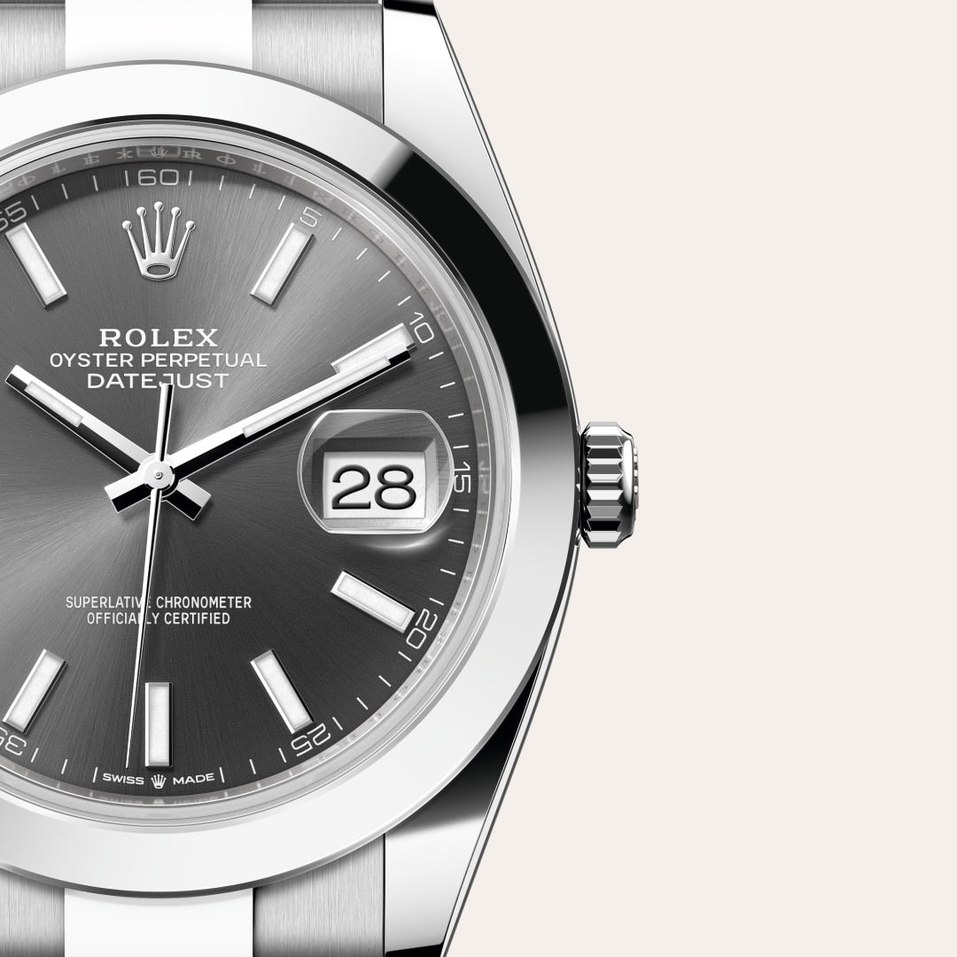 Close-up of a Rolex Datejust watch with a grey dial displaying the date “28” and silver hour markers.