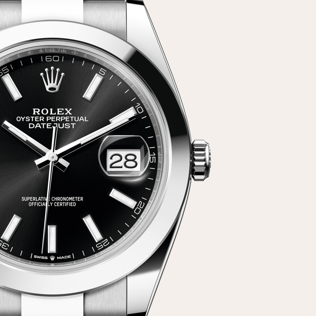Close-up of a Rolex Datejust watch with a black dial, silver hands, and the date showing 28.