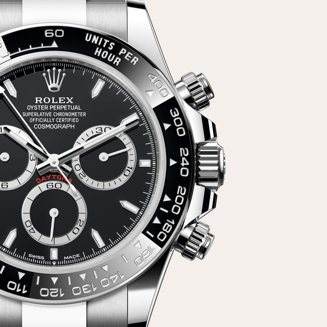 Close-up of a Rolex Cosmograph Daytona watch with a black dial and three subdials, showing part of the bezel.