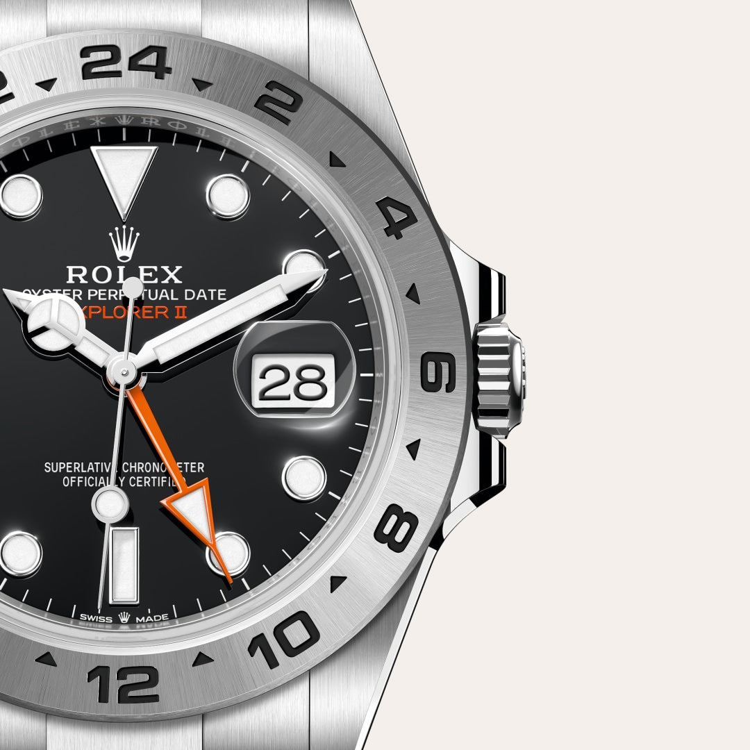 Close-up of a Rolex Explorer II watch showing the date as 28, with black dial and silver bezel.