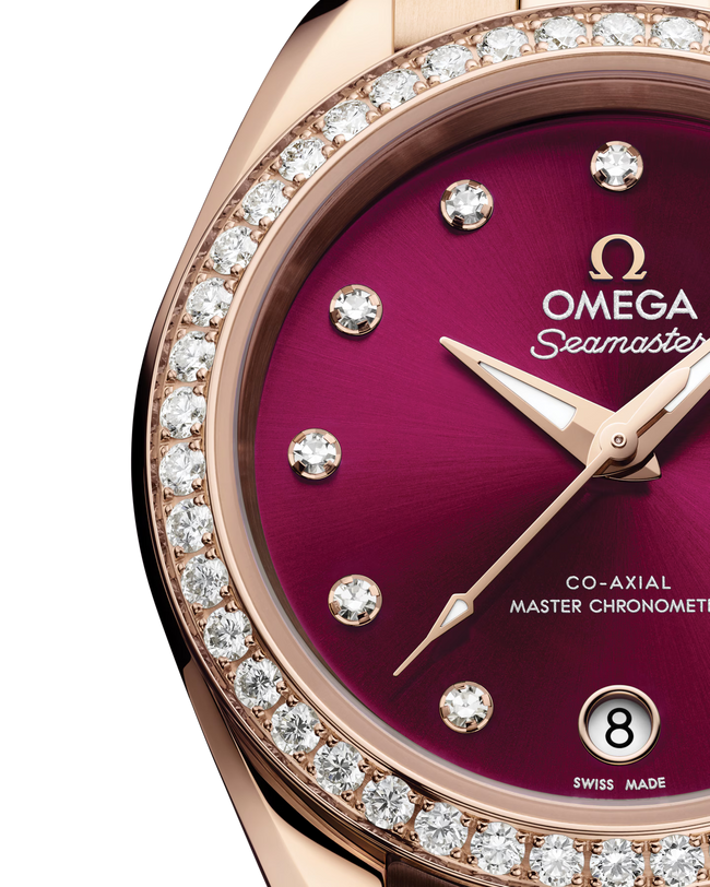 Close up view of the dial of an Omega Seamaster watch with a burgundy dial and diamonds at the hour marks with a rose-gold bracelet