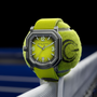 The Gerald Charles Maestro GC Sport Tennis Limited Edition watch, featuring a tennis ball-inspired green face and strap, is wrapped around a tennis ball on a net.