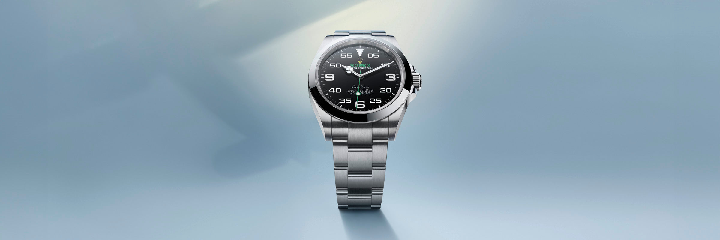 A silver wristwatch with a black dial and white numbers, displayed against a light blue gradient background.