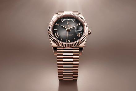 A gold wristwatch with a black dial and Roman numerals displayed on a matching gold metal band.