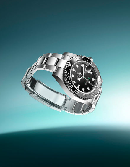 Silver luxury wristwatch with a black dial and metal band, floating against a teal gradient background.