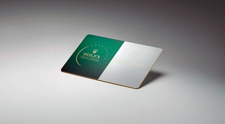 A green and white Rolex warranty card displayed on a gray gradient background.