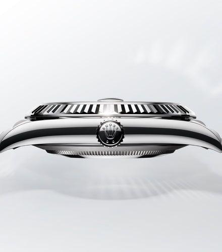Close-up side view of a luxury wristwatch case with a crown logo, set against a light background.
