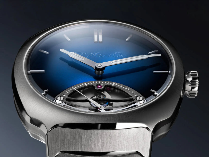 Stainless steel watch with midnight blue fumé dial, white hour markers, silver hands, and visible retrograde seconds mechanis