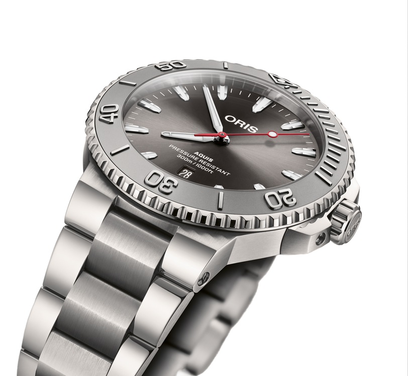 The Oris Aquis Date Relief, a stainless steel dive watch with a grey dial, date window, and rotating bezel, is shown angled on a white background.